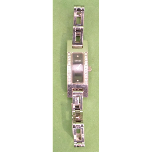 507 - A Ladies Gucci Black Dial Wristwatch mounted with 24 diamonds, model number 3900L, having matching s... 