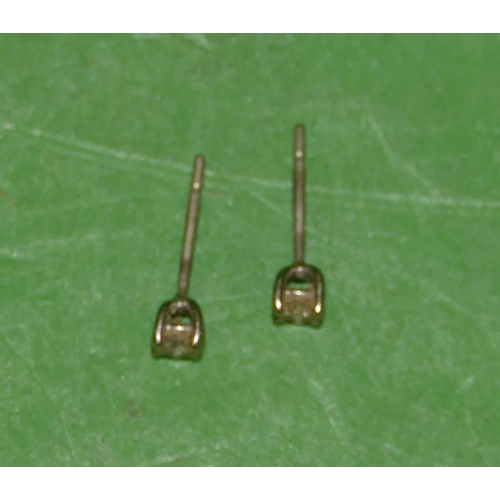 517 - A Pair of Small Solitaire Diamond Earrings, approximately 0.150ct.