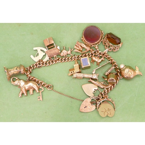 583 - A 9ct Gold Charm Bracelet having 2 padlock clasps and mounted with 16 charms and 2 seals (1 not gold... 