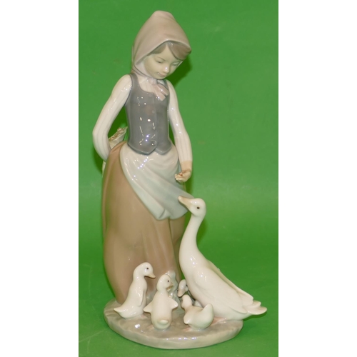 155 - A Lladro Group of a young girl feeding various birds, 24cm high.