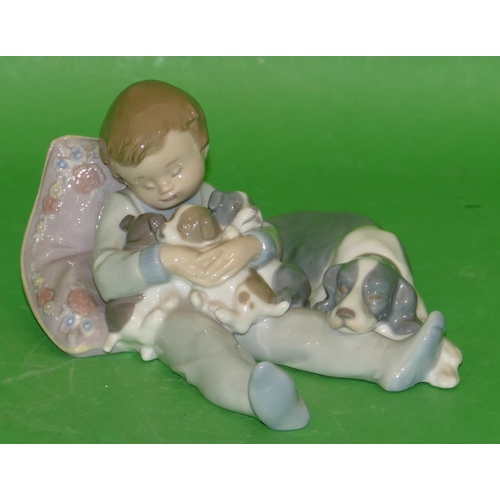 160 - A Lladro Group of a young baby sleeping with dog holding puppies, 18.5cm long.