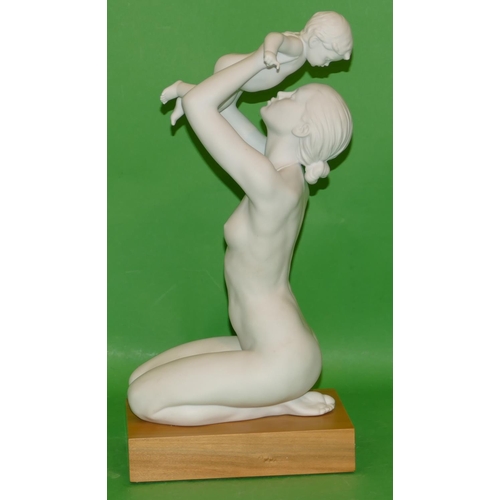 190 - A Lladro Matt White Figure of a female kneeling nude, holding aloft her child on rectangular hardwoo... 