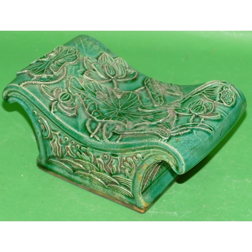 214 - An Oriental Green Glazed China Concave Shaped Pillow having raised floral and leaf decoration, 23.5c... 