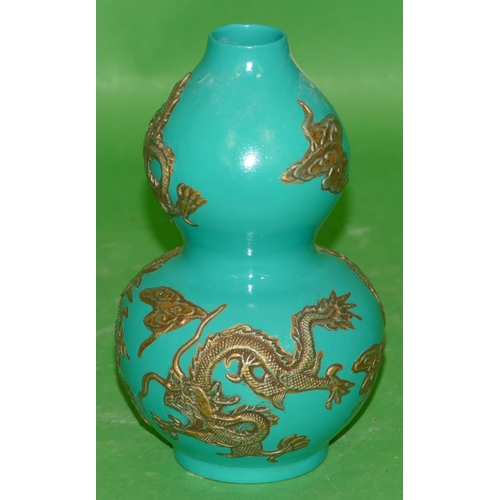 220 - An Oriental Gourd Vase on green ground having raised gilt dragon decoration, 17cm high.