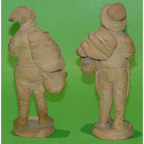 38 - A Pair of Earthenware Figures of standing gentleman holding baskets on round bases 15cm high.