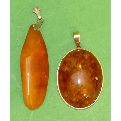 540 - A 9ct Gold Oval Amber Drop Pendant, also another amber drop pendant (2).