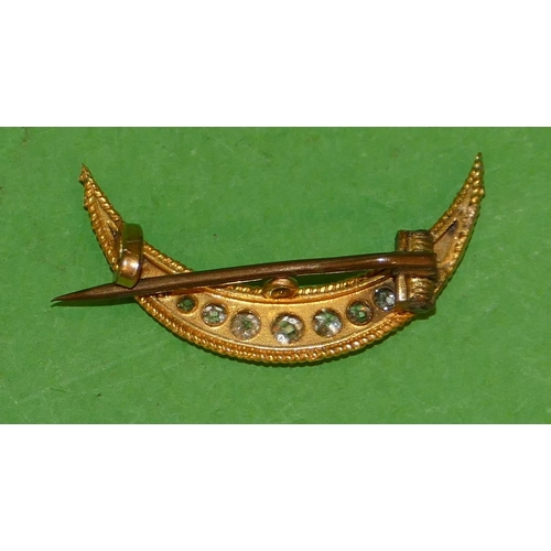 543 - A Small Gold Crescent Moon Brooch mounted with graduated diamonds (1 diamond missing) 2.4cm wide.