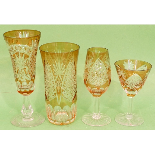 85 - An Amber and Clear Cut Glass Suite of Drinking Glasses, comprising 10 x round trumpet shaped champag... 