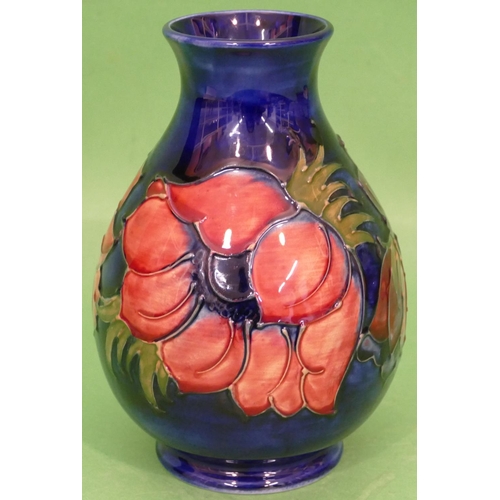 86 - A Moorcroft Round Bulbous Thin Necked Trumpet Shaped Vase on blue ground with multicoloured floral a... 