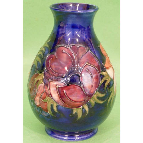 86 - A Moorcroft Round Bulbous Thin Necked Trumpet Shaped Vase on blue ground with multicoloured floral a... 