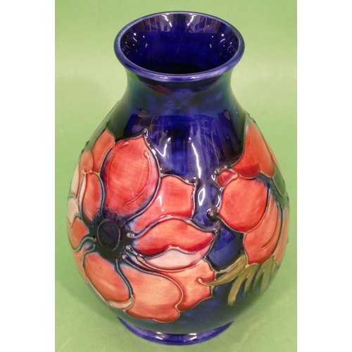 86 - A Moorcroft Round Bulbous Thin Necked Trumpet Shaped Vase on blue ground with multicoloured floral a... 