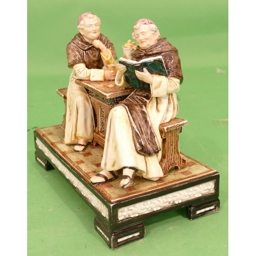 153 - A Continental Glazed Earthenware Group of 2 monks seated at a table on rectangular shaped base, 27.5... 