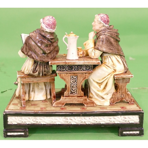 153 - A Continental Glazed Earthenware Group of 2 monks seated at a table on rectangular shaped base, 27.5... 