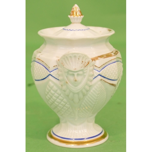 161 - A Meissen Round Bulbous Shaped Lidded Pot having figure, mask head handles, on white ground having b... 