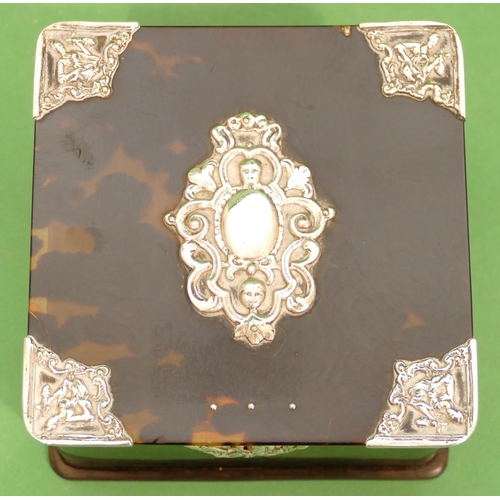 330 - A Square Tortoiseshell Box mounted with silver corners having figure motifs, hinged lid (hinge a/f),... 