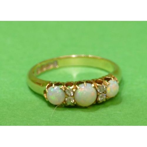 452 - An 18ct Gold Ladies Ring set with 3 centre opals, interspersed by 4 small diamonds, size N.