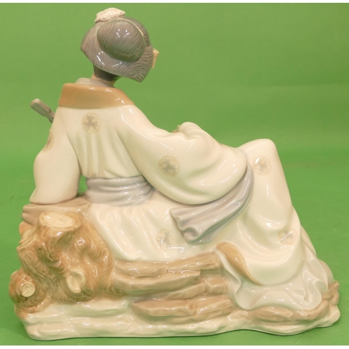 46 - A Nao Figure of a seated geisha girl holding a musical instrument, 26cm high.