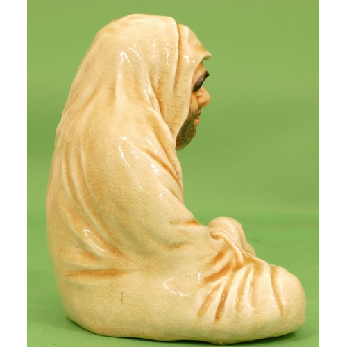 53 - An Oriental Figure of a seated buddha on cream ground, 25cm high.