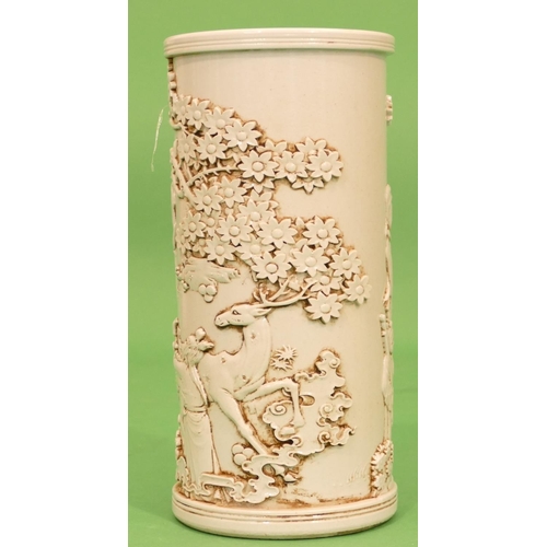 54 - An Oriental Cylindrical Brush Pot on white ground having raised Oriental figure, animal and tree dec... 