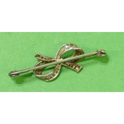 634 - A 9ct White Gold Bar Brooch having centre ribbon motif, 5cm wide, 4.1g.