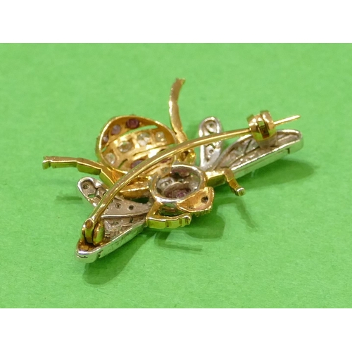 667 - A 2 Coloured Gold Insect Brooch mounted with 7 rubies interspersed by 40 various diamonds, having sa... 