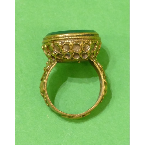 676 - A Roman Style Circular Ring with green stone, having figurehead decoration, size Q/R.