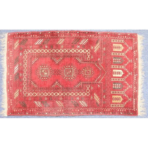 706 - An Afghan Rug on red ground having 3 medallions, 1m 20cm x 77cm.