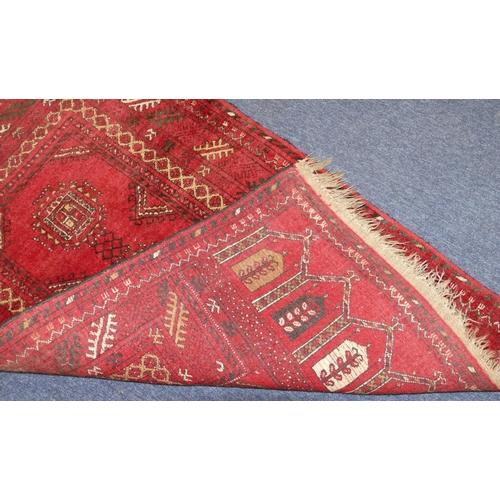 706 - An Afghan Rug on red ground having 3 medallions, 1m 20cm x 77cm.