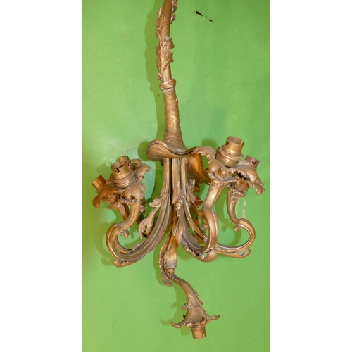 781 - A Gilt and Metal Hanging 7 Light Centre Light Fitting having scroll arm with raised leaf decoration,... 