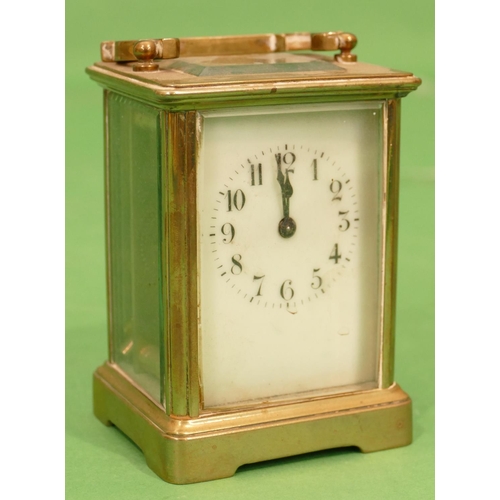 820 - A Brass Carriage Clock having swing overhead handle, cream enamelled dial with Arabic numerals, 12cm... 