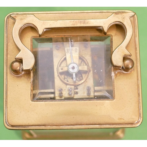 820 - A Brass Carriage Clock having swing overhead handle, cream enamelled dial with Arabic numerals, 12cm... 