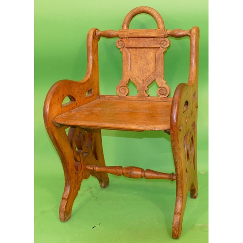 886 - A 19th Century Oak Hall Chair having shield back, solid seat on pierced splat end supports, centre t... 