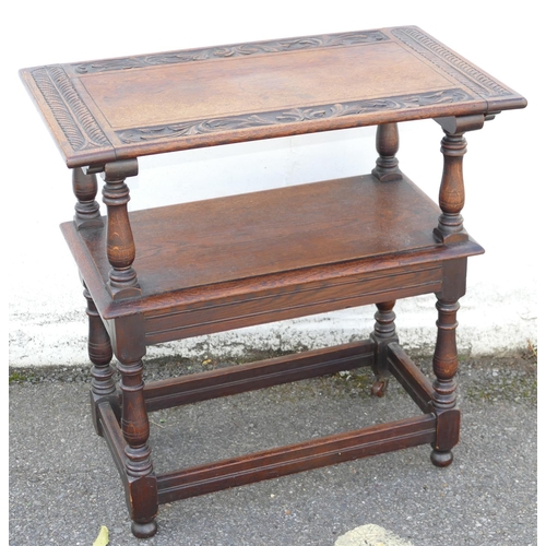 893 - An Oak Monks Bench having sliding top with carved leaf and scroll decoration, turned supports, solid... 