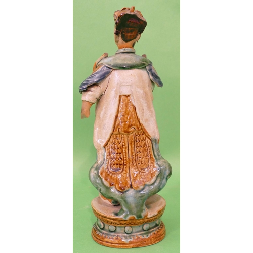 19 - An Oriental Glazed Earthenware Figure of a standing gentleman (both arms from elbows missing), on ov... 