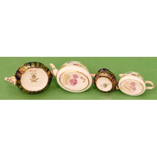 74 - A Minton Miniature Oval Teapot and matching cream jug on white ground with multicoloured floral leaf... 