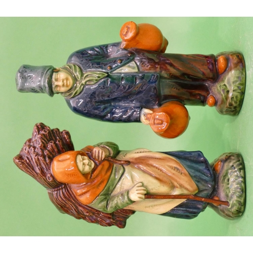 110 - A Pair of Glazed Earthenware Figures of elderly gentleman and lady carrying bundle of wood and jugs,... 