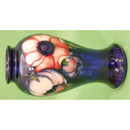 111 - A Moorcroft Round Bulbous Thin Necked Vase on blue ground with multicoloured, floral and leaf decora... 