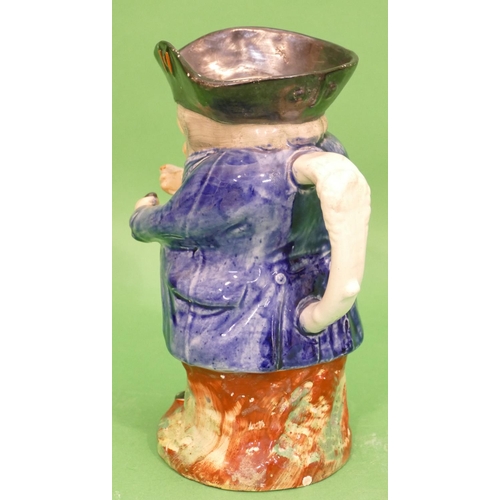 101 - A 19th Century Toby Jug in form of a standing potbellied gentleman in blue coat, taking snuff, 21.5c... 