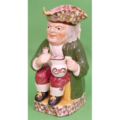 102 - A 19th Century Toby Jug in form of a seated gentleman in green coat holding jug and glass, having sp... 