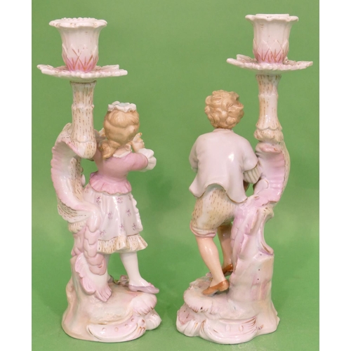 104 - A Pair of Continental China Figured Candlesticks in form of young gentleman and lady holding birds w... 