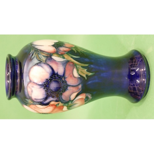 111 - A Moorcroft Round Bulbous Thin Necked Vase on blue ground with multicoloured, floral and leaf decora... 