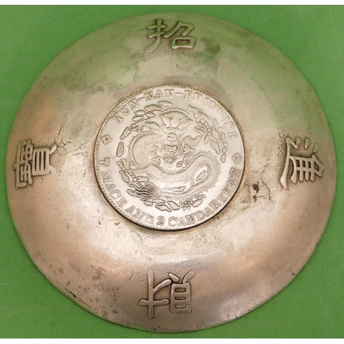 240 - An Oriental Silvered Dish having raised dragon decoration with inset coin to centre, 9cm diameter.