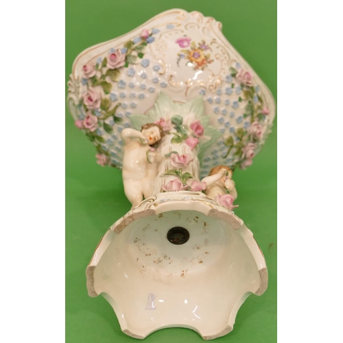 53 - A Continental China Comport having 2 raised cupids with all over encrusted floral, leaf and gilt dec... 