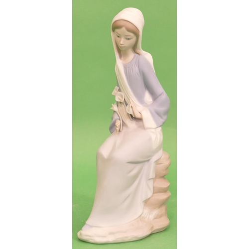 54 - A Lladro Figure of a seated lady in blue dress, 24cm high.