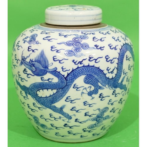 46 - An Oriental Round Bulbous Lidded Ginger Jar on blue and white ground having dragon and phoenix decor... 