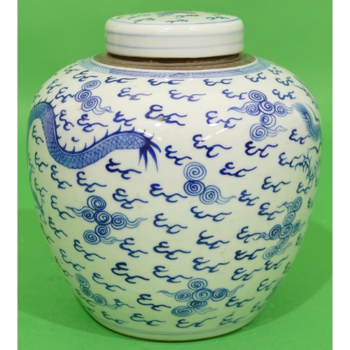 46 - An Oriental Round Bulbous Lidded Ginger Jar on blue and white ground having dragon and phoenix decor... 