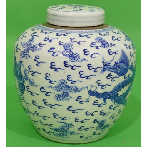 46 - An Oriental Round Bulbous Lidded Ginger Jar on blue and white ground having dragon and phoenix decor... 