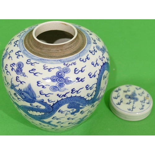 46 - An Oriental Round Bulbous Lidded Ginger Jar on blue and white ground having dragon and phoenix decor... 