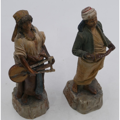 101 - A pair of Continental earthenware figures of standing gentleman and lady holding a sword and musical... 