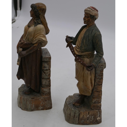 101 - A pair of Continental earthenware figures of standing gentleman and lady holding a sword and musical... 